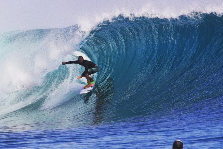 a man riding a wave on a surfboard in the ocean