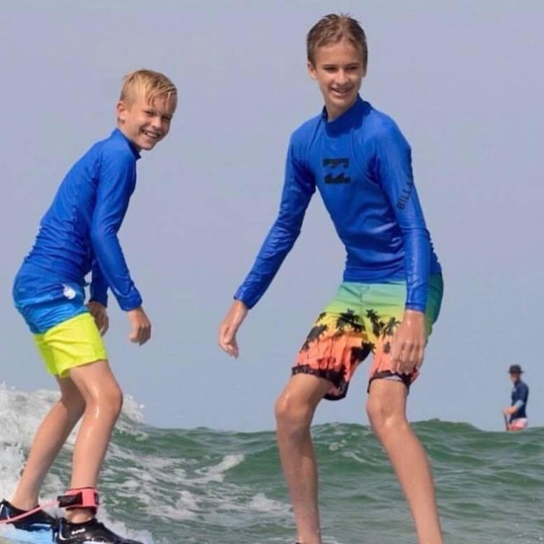 a young girl riding a wave on a surfboard in the water